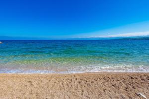 uma praia de areia com o oceano ao fundo em Blue Waves Resort em Malinska