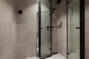 a shower with a glass door in a bathroom at Modern - Work friendly - Quiet area in Bergen