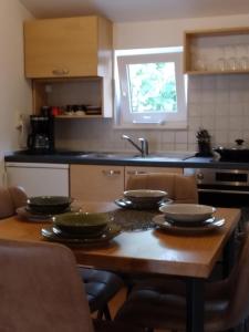 una cocina con una mesa de madera con platos. en Apartments Anita Frane, en Vodice