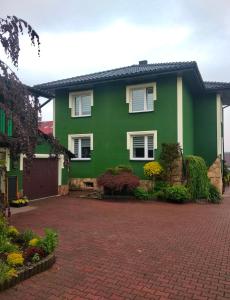 une maison verte avec une allée en briques rouges dans l'établissement Zielone Okiennice, à Bachowice