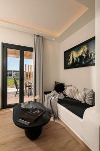 a living room with a bed and a table in it at Iphimedeia Luxury Hotel & Suites in Naxos Chora