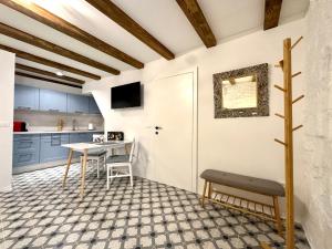 a kitchen with a table and a bench in a room at Apartments Angela in Piran