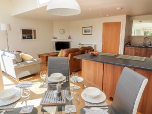a kitchen and living room with a table and chairs at Ash Meadows in Carnforth