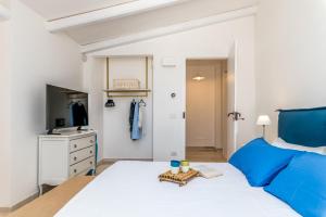 een slaapkamer met een groot bed en een televisie bij Trulli Ericla Resort in Castellana Grotte
