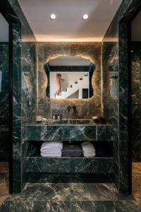 y baño con lavabo y espejo. en Iphimedeia Luxury Hotel & Suites, en Naxos Chora