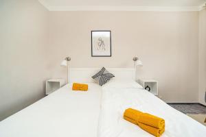 a white bed with two yellow pillows on it at Cosy studio with terrace by tram in Prague
