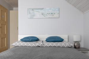1 dormitorio con 1 cama con 2 almohadas azules en Pokoje gościnne Anna, en Rewa