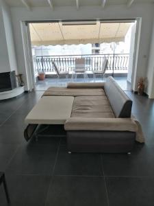 a large couch in a room with a balcony at Manolis Loft in Piraeus