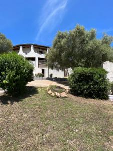 a house with a yard with bushes and trees at Casa Le Cicale in Porto Istana