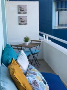 d'un canapé avec des oreillers sur un balcon avec une table. dans l'établissement Espacio tranquilo cerca del mar, à Santa Cruz de Tenerife
