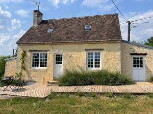 a stone house with a wooden deck in front of it at Loue charmante maison de vacances à 10 mns de Bellême (61) in Saint-Martin-du-Vieux-Bellême