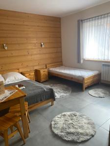 a bedroom with two beds and a table and a window at U Bizioma in Murzasichle