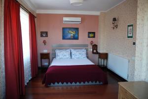 Schlafzimmer mit einem Bett und roten Vorhängen in der Unterkunft L'isola Guesthouse in Heybeliada