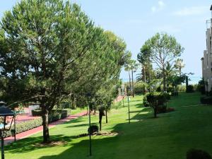 um parque com árvores e relva verde e um passeio em Apartamento premium un dormitorio ALCAUDON na Isla Canela