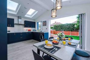 een keuken en een woonkamer met een tafel met eten erop bij Sandileigh Drive by YourStays in Altrincham