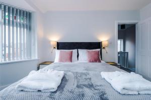 een slaapkamer met een groot bed met 2 witte kussens bij Sandileigh Drive by YourStays in Altrincham