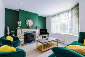een woonkamer met groene muren en een open haard bij Sandileigh Drive by YourStays in Altrincham