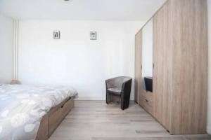 a bedroom with a bed and a chair and a mirror at 2 pièces tout confort à Alfortville - chez Christophe in Alfortville