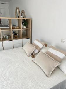 - un lit blanc avec des oreillers au-dessus dans l'établissement Girasoles Benalmádena Beach, à Benalmádena