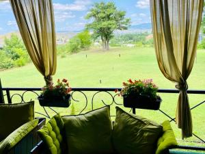 eine Couch auf einem Balkon mit Blick auf einen Golfplatz in der Unterkunft Hotel Park in Negotino