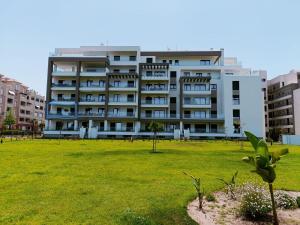 a large building with a grassy field in front of it at Malvagon Isla Canela los flamencos in Isla Canela