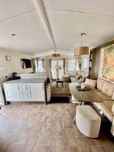 a living room with a couch and a table at Caravan on Mersea Island Away Resorts Quiet Location in East Mersea