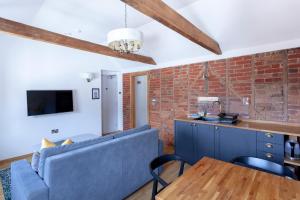 a living room with a blue couch and a brick wall at Apartment 6 at Number 8: City centre, 1 bedroom, sofa bed in lounge in Kent