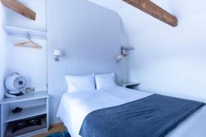 een slaapkamer met een wit bed en een blauwe deken bij Apartment 6 at Number 8: City centre, 1 bedroom, sofa bed in lounge in Kent
