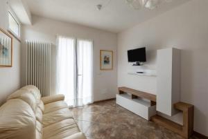 a living room with a couch and a tv at Casa Valentina, casa intera vicino al mare in Carrara