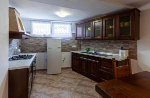 a kitchen with wooden cabinets and a white refrigerator at Casa Valentina, casa intera vicino al mare in Carrara