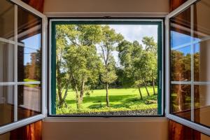 a window with a view of a golf course at Batalha Family House in Fenais da Luz