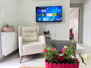 a living room with a chair and a tv on the wall at Beautiful house close to the sea in the center of MERSİN in Mersin