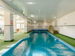 a swimming pool in a building with blue water at Craiglea Lodge & Barn in Latheron