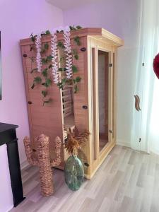 LʼHorme的住宿－Appartement avec Spa et Sauna，一间设有镜子和花瓶的房间