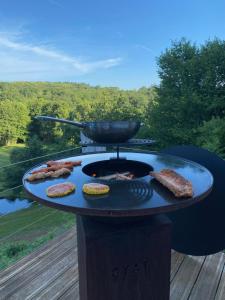 a bbq with meat andurgers on a grill at Veyrinas 43 in Saint-Yrieix-la-Perche