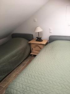 two beds in a room with a lamp on a table at Le Clos De La Perdrix in Mons-en-Pévèle
