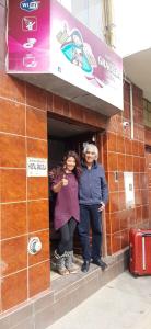 dos personas de pie en la puerta de un edificio en Hostal Graciela, en Oruro