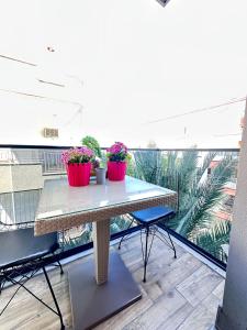 a balcony with a table and two potted plants on it at Beautiful house close to the sea in the center of MERSİN in Mersin