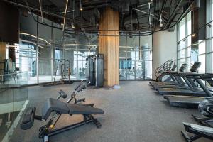 un gimnasio con una fila de trenzas y máquinas de cardio en The Suite Dubai 15 Northside Luxury Living en Dubái