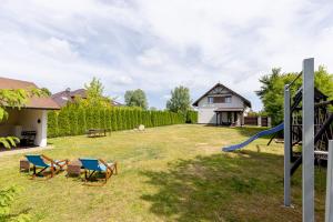 a yard with two chairs and a slide at Pokoje gościnne Anna in Rewa