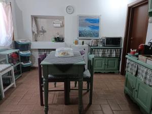 a kitchen with green cabinets and a table with chairs at Lo scrigno di Simon in Senigallia