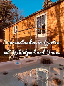una casa con piscina e le parole "ournesteaded" in saranater di Zirkuswagen mit Outdoor Whirlpool und Garten a Petershagen