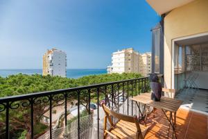 a balcony with a table and chairs and the ocean at Ático Alhamar in Mijas