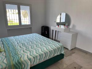 1 dormitorio con cama, tocador y espejo en VillaLina Haut Standing Djerba, en Ajim