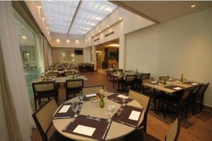 uma sala de jantar com mesas e cadeiras num restaurante em Linda suíte de hotel Harry no Rio de Janeiro