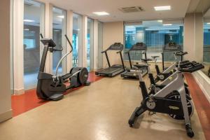a gym with several treadmills and elliptical machines at Linda suíte de hotel Harry in Rio de Janeiro