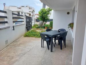 una mesa negra y sillas sentadas en un patio en Incantos Charme B&B & Apartment en Tortolì