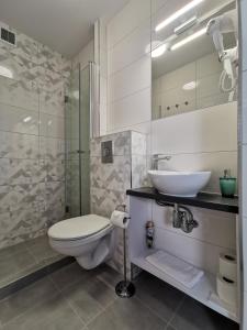 y baño con aseo, lavabo y ducha. en Villa Bianco, en Międzyzdroje