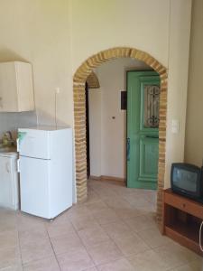 a kitchen with a white refrigerator and a green door at Didima in Didyma