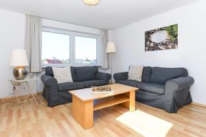 Sala de estar con 2 sofás y mesa en Haus Hafenblick, en Bensersiel